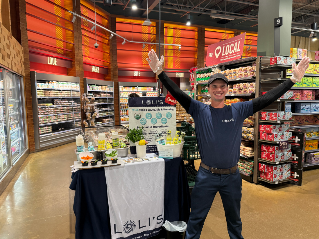 PTS representative confidently engaging a shopper in a grocery aisle